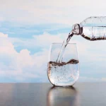 Rainwater şişesinden bardağa su dökülüyor, kaliteli doğal içme suyu.